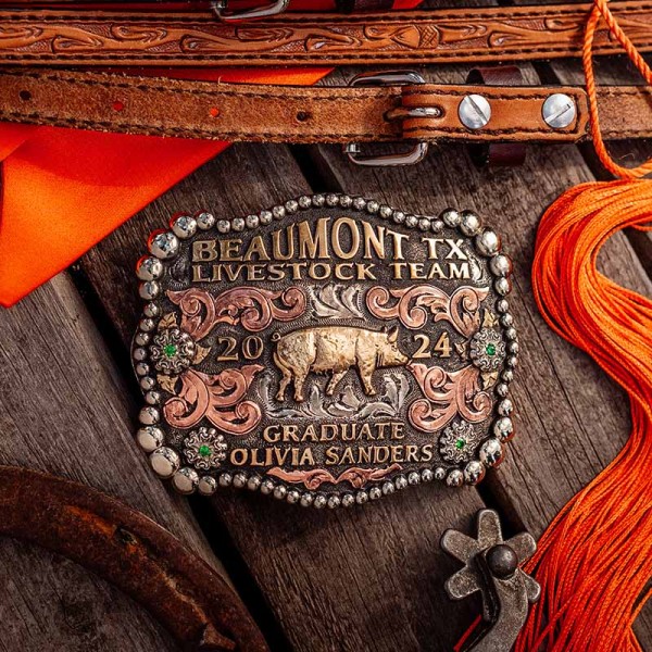 A custom graduation belt buckle for Beaumont Texas Livestock Team with personalized name featuring a golden pig figure